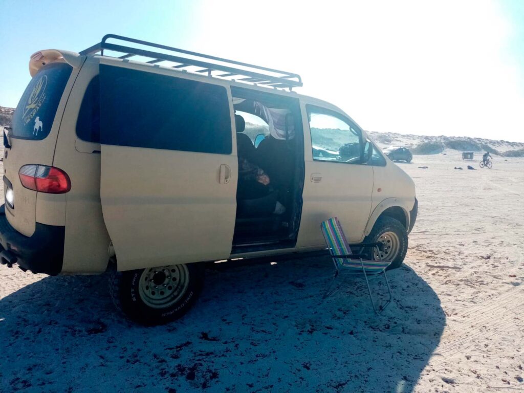camper hyundai h1 4x4 verniciato con raptor bed liner ral desert tan su una spiaggia